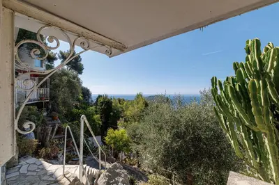 a view from the balcony of a house with a cactus at 73 CORNE D OR - Duplex plein SUD, VUE MER, BALCON in Villefranche-sur-Mer