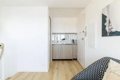 a small apartment with white walls and a kitchen at 73 CORNE D OR - Duplex plein SUD, VUE MER, BALCON in Villefranche-sur-Mer