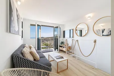 a living room with a couch and a large window at 73 CORNE D OR - Duplex plein SUD, VUE MER, BALCON in Villefranche-sur-Mer