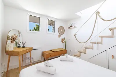 a white room with a staircase and a desk at 73 CORNE D OR - Duplex plein SUD, VUE MER, BALCON in Villefranche-sur-Mer