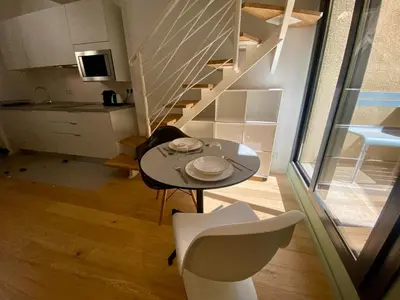 a small table and chairs in a room with a staircase at Studio Beautes FSHH in Nice