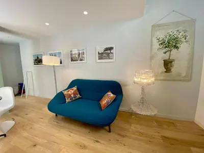 a living room with a blue chair and a lamp at Studio Beautes FSHH in Nice