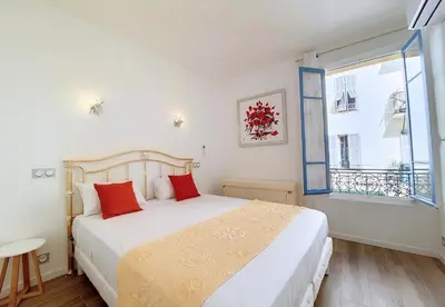 a bedroom with a bed with red pillows and a window at Nestor&Jeeves - BRISE DE NICE - Balcony - Central in Nice