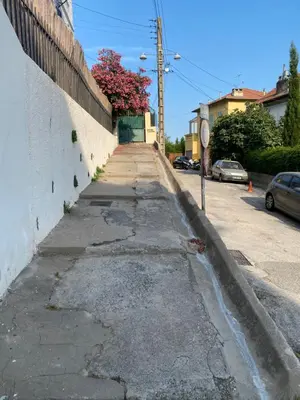 an empty street with a wall and a tree at L'Oustalet in Nice