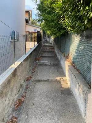 an alley with a fence next to a wall at L'Oustalet in Nice