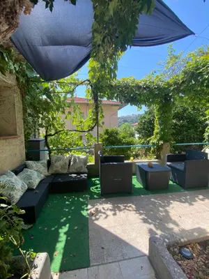 a patio with couches and an umbrella at L'Oustalet in Nice