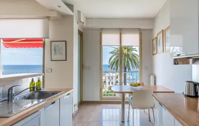 a kitchen with a table and a view of the ocean at Nice Absea le Port 1 in Nice