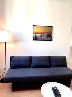 a blue couch in a living room with a tv at Collet Résidence in Nice