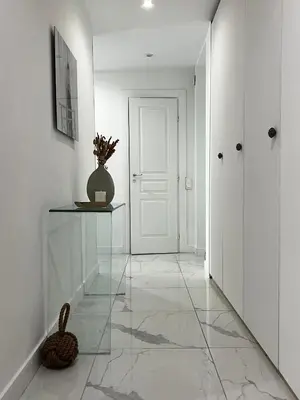 a hallway with a white door and a vase on a table at Appartement niçois au coeur du triangle d'or in Nice