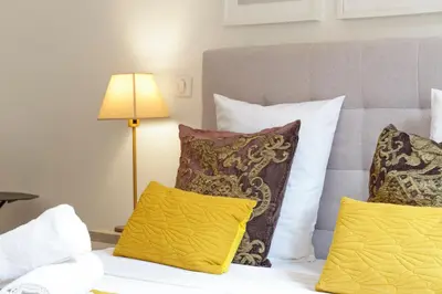 a bed with three pillows and a lamp on it at Nice Renting - ROSSETTI - Modern Haven Heart of Old Nice in Nice