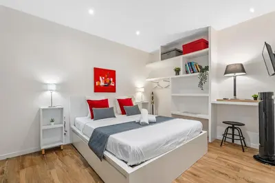 a white bedroom with a large bed with red pillows at Nice Renting - ROSSETTI - Modern Haven Heart of Old Nice in Nice