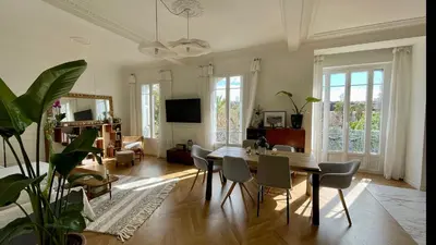 a living room with a dining room table and chairs at Bright, Spacious 2 Bedroom Apartment, Walk to Beach & Old Town in Nice