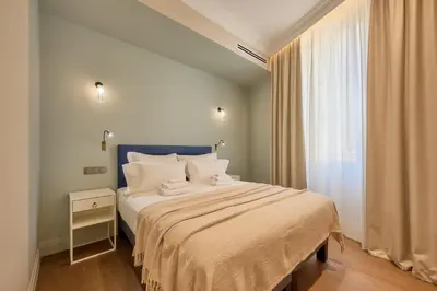 a bedroom with a bed with white pillows and a window at Aparthotel 9 ALBERTI Nice Centre in Nice