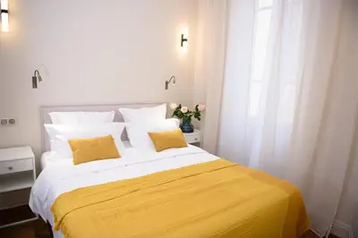 a bedroom with a large bed with two yellow pillows at Aparthotel 9 ALBERTI Nice Centre in Nice