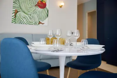 a white table with wine glasses and blue chairs at Aparthotel 9 ALBERTI Nice Centre in Nice