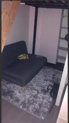 a black chair in a room with a ladder at appartement proche centre ville in Nice