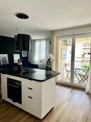 a kitchen with a island with a black counter top at Appartement neuf et rénové promenade des anglais in Nice