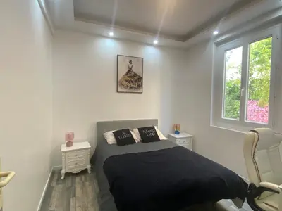 a bedroom with a bed with black sheets and a window at Charming house near Center Nice with new air conditioner in Nice