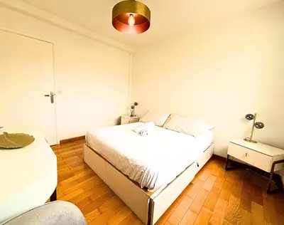 a bedroom with a white bed and a lamp at Le St Charles in Saint-Laurent-du-Var