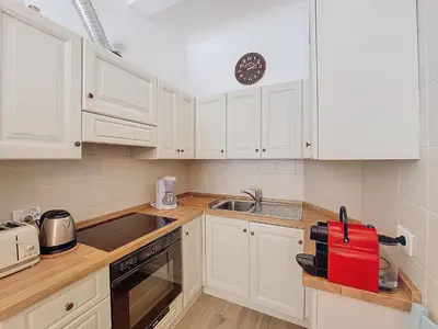 a kitchen with white cabinets and a sink and a clock at Nestor&Jeeves - VILLA FAY - Near Beach - Promenade in Nice