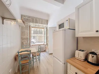 a kitchen with a small table and a kitchen with a refrigerator at Nestor&Jeeves - VILLA FAY - Near Beach - Promenade in Nice