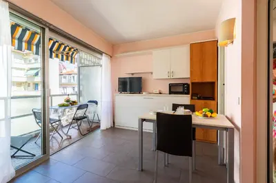 a kitchen and dining room with a table and chairs at Royal Luxembourg AP4397 By Riviera Holiday Homes in Nice