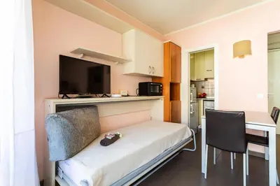 a small room with a bed with a tv and a desk at Royal Luxembourg AP4397 By Riviera Holiday Homes in Nice