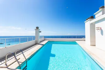 a swimming pool on a balcony with the ocean in the background at Royal Luxembourg AP4397 By Riviera Holiday Homes in Nice