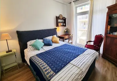 a bedroom with a bed with a blue and white blanket at 