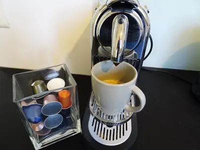 a coffee maker with a cup on a table at 