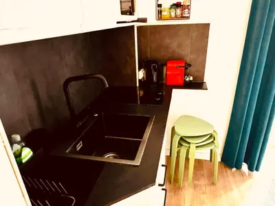 a kitchen with a sink and a green stool at All new charming 1br hyper centre with balcony and AC in Nice
