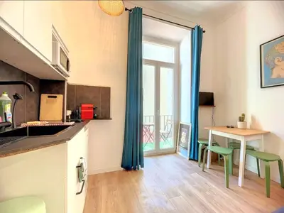 a kitchen with a table and chairs and a window at All new charming 1br hyper centre with balcony and AC in Nice