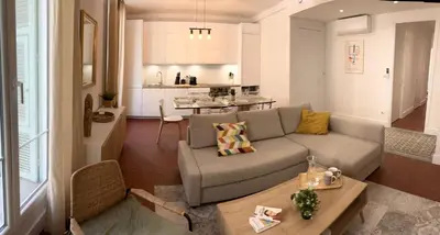 a living room with a couch and a table at Magnifique T4 - Spacieux Haut Standing - AC - WIFI - Coeur de Nice in Nice