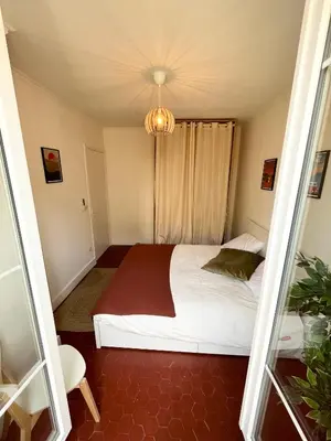 a small bedroom with a bed and a chandelier at Magnifique T4 - Spacieux Haut Standing - AC - WIFI - Coeur de Nice in Nice