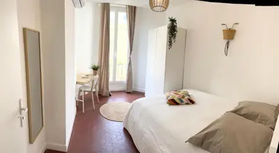 a white bedroom with a bed and a table at Magnifique T4 - Spacieux Haut Standing - AC - WIFI - Coeur de Nice in Nice