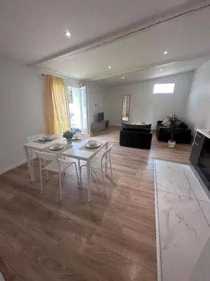 a living room with a white table and a couch at appartement au calme avec jardin privatif dans maison in Cagnes-sur-Mer