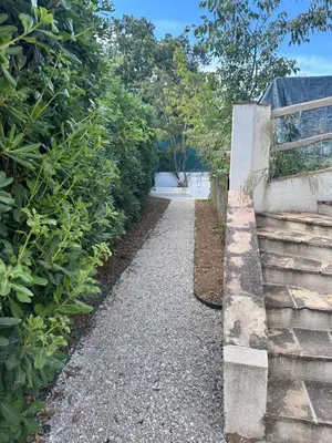 a garden path next to a retaining wall at appartement au calme avec jardin privatif dans maison in Cagnes-sur-Mer