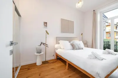 a white bedroom with two beds and a window at Soleil de la Buffa - Un joyau central à 3 min des plages in Nice