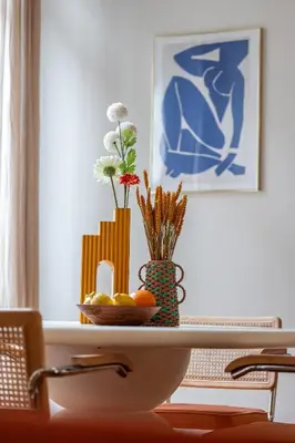 a table with a bowl of fruit and a vase with flowers at Soleil de la Buffa - Un joyau central à 3 min des plages in Nice