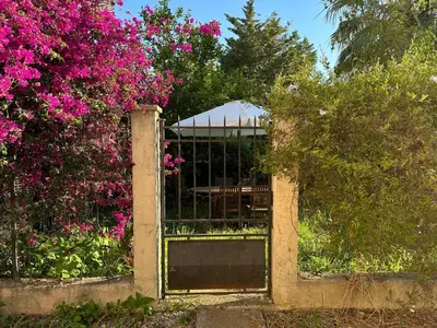 an open gate in a garden with pink flowers at STUDIO dans Villa à Nice Ouest in Nice
