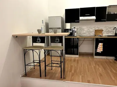 a kitchen with two bar stools and a counter at Charmant studio avec mezzanine in Nice