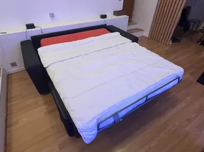 a large bed sitting in a room with at Charmant studio avec mezzanine in Nice