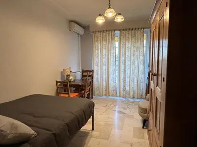 a bedroom with a bed and a table and a chair at Studio style vintage à Nice in Nice