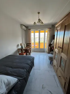 a bedroom with a bed and a dining room with a table at Studio style vintage à Nice in Nice