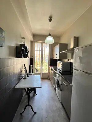 a kitchen with a table and a refrigerator at Studio style vintage à Nice in Nice