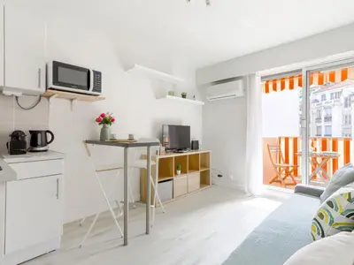 a small white kitchen with a table in a room at Studio Le Maréchal by Interhome in Nice