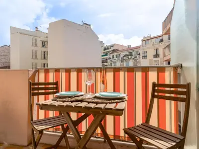 a table with two chairs and a wine glass on a balcony at Studio Le Maréchal by Interhome in Nice