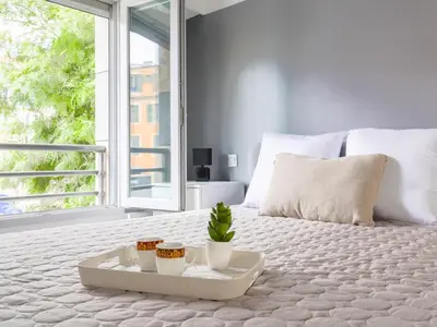 a white bed with two cups and a tray on it at Apartment Jardin Pastorelli by Interhome in Nice