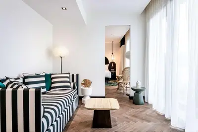 a living room with a couch and a table at Doubletree By Hilton Nice Centre Iconic in Nice