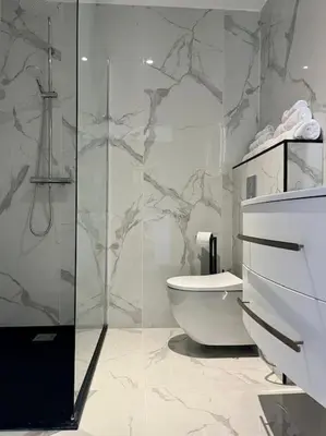 a bathroom with a toilet and a glass shower at New apartment with swimming pool in Beaulieu-sur-Mer